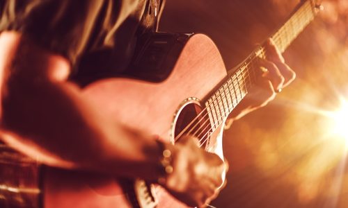 Acoustic Guitar Playing. Men Playing Acoustic Guitar Closeup Photography.